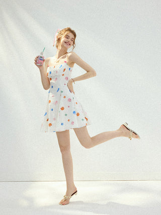 Mini dress with seashell neckline and ruffle details, ideal for vacation or resort styling