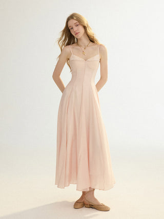 A model wearing the SINCETHEN Pink Haze Maxi Dress, highlighting its elegant flowing silhouette and soft pink color.