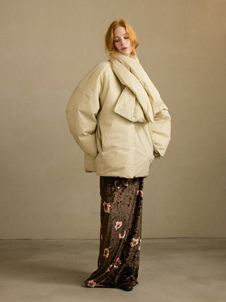 Model wearing the Plumpy Muffler Duck Down Jacket, a nylon duck down puffer with detachable matching scarf, zip front pockets and elastic cuffs for a warm winter look – SINCETHEN. 