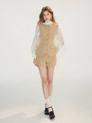 Woman wearing a minimal sandstone vest layered for a formal office look