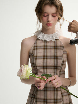 Woman wearing a tartan check halter neck mini dress – vintage-inspired, stylish, and perfect for retro styling.